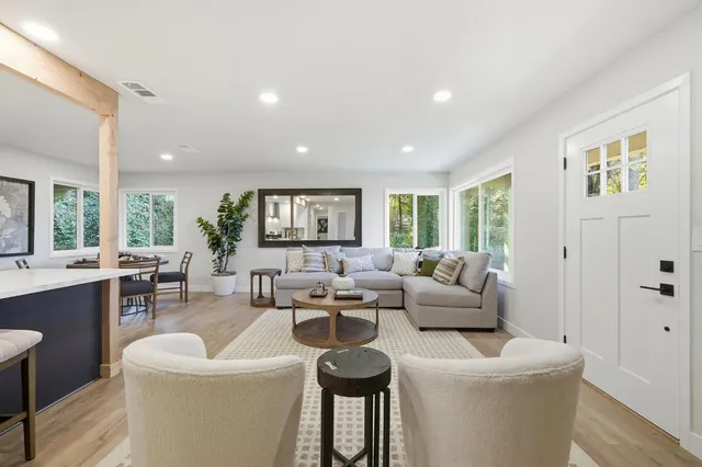 a living room with furniture a window and a dining table with wooden floor