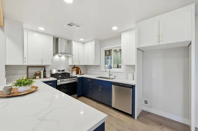 a kitchen with kitchen island granite countertop a sink stainless steel appliances and cabinets