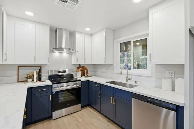 a kitchen with a sink a stove and cabinets