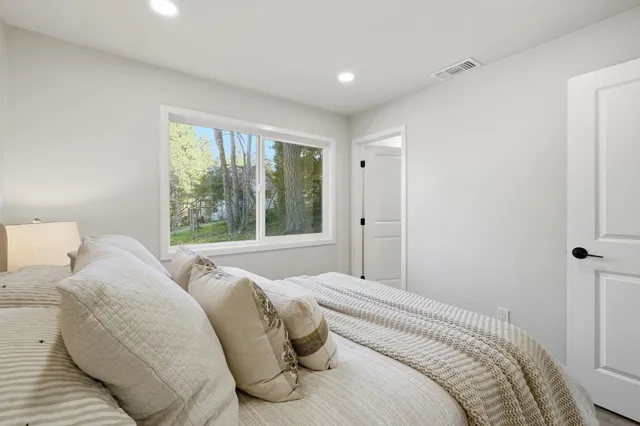a bedroom with a bed and a large window