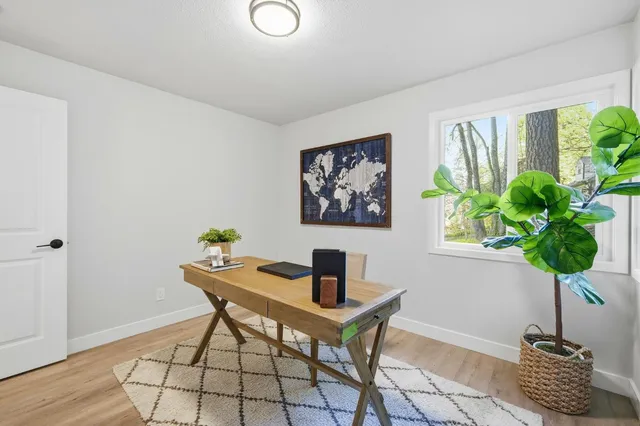 a table room with vase of flowers and wooden floor
