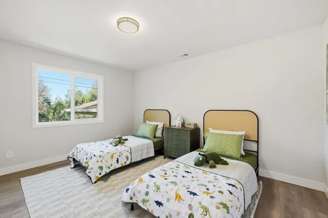 a bedroom with two beds and a painting on the wall