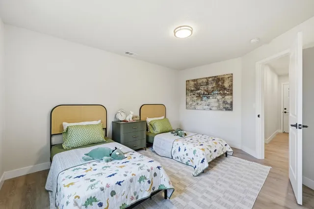 a bedroom with two beds and painting on the wall