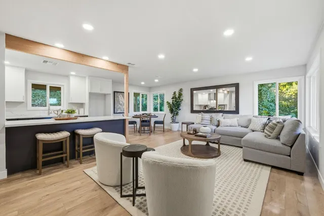 a living room with fireplace furniture and a large window