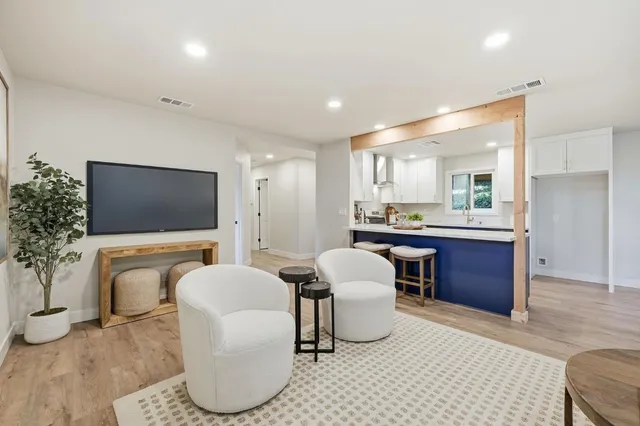 a living room with furniture a flat screen tv and a large window