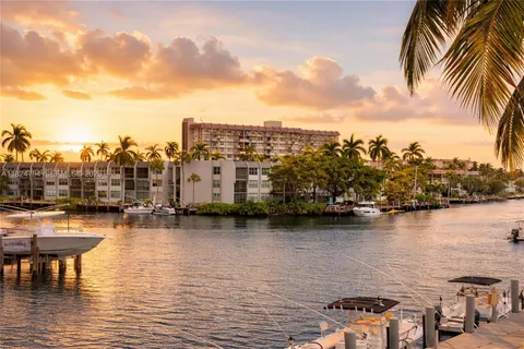a view of a lake with boats and palm trees