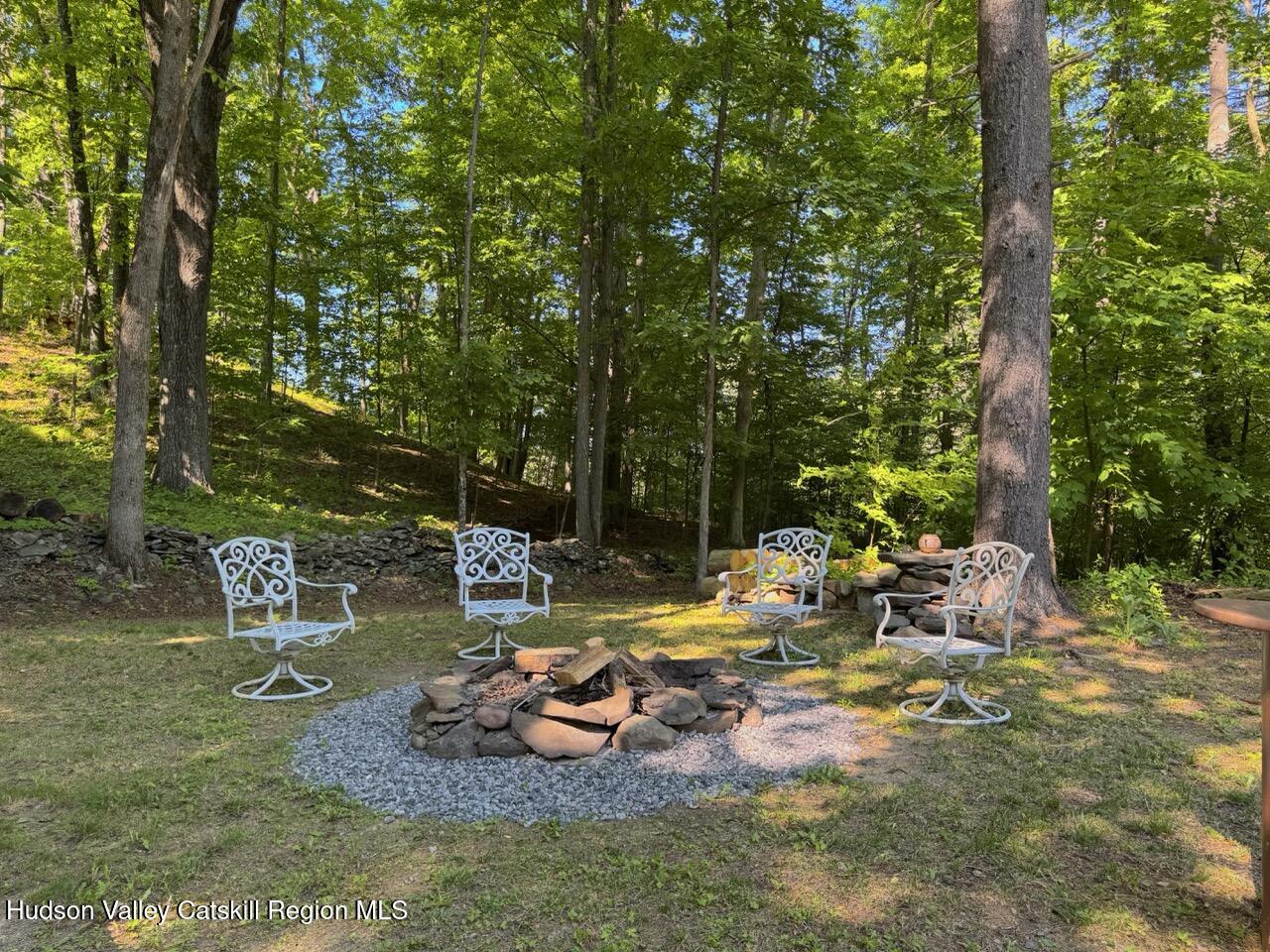 177 Webber Road Earlton, NY 12058 - Photo 16 of 50 a view of a backyard with lawn chairs and a fire pit