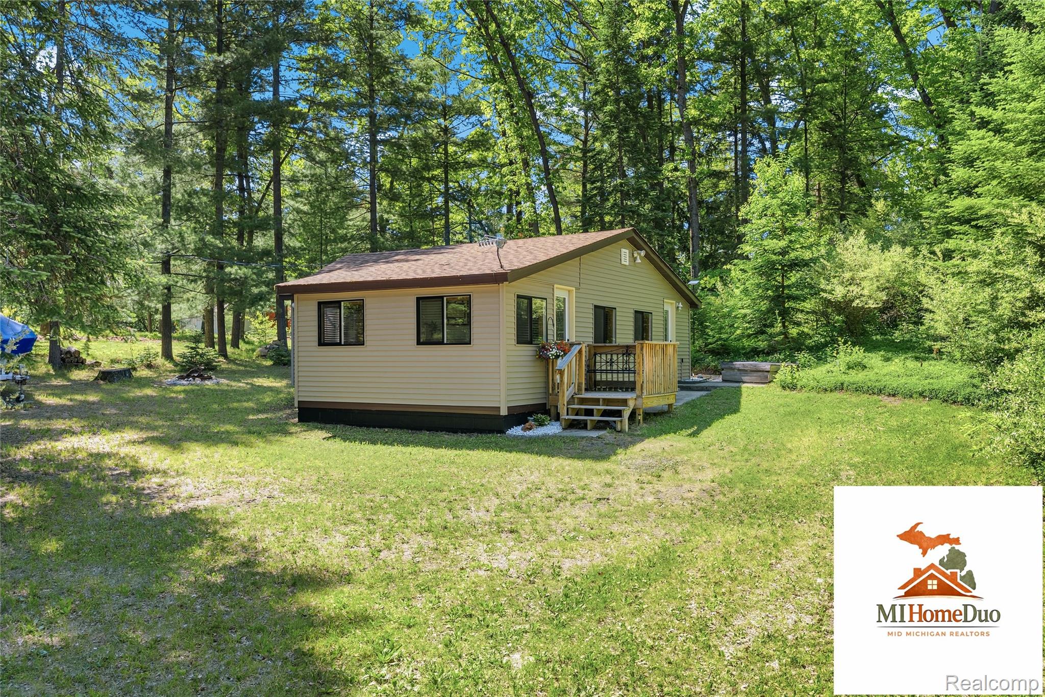 6960 Rumsay Street Harrison, MI 48625 - Photo 2 of 29 Single-story residence featuring light-colored siding, a brown shingled roof, and dark-trimmed windows