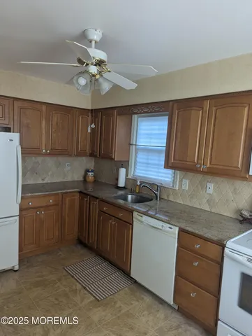 a kitchen with a sink a stove cabinets and a refrigerator