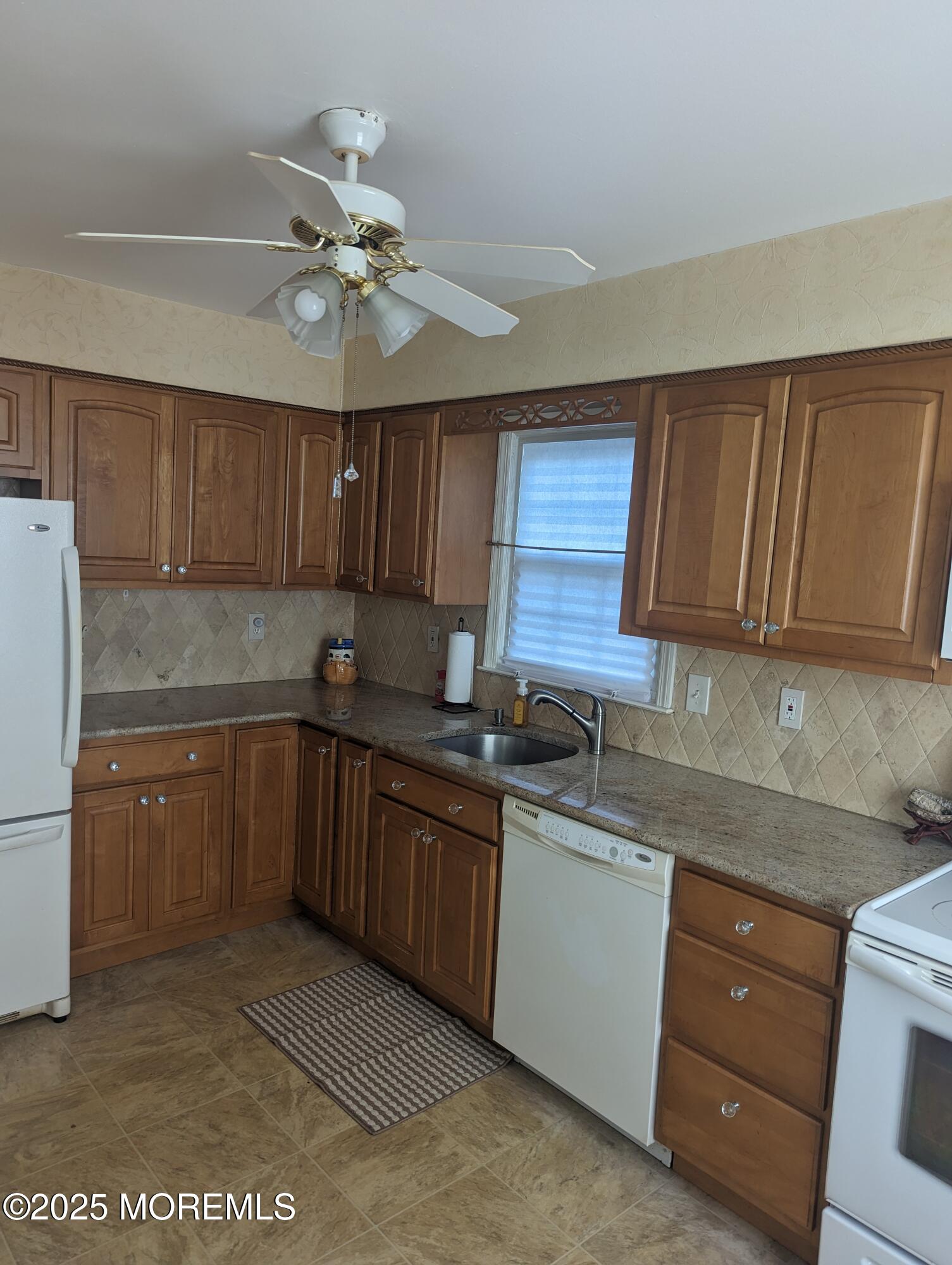 33 Dover Walk, Unit 633 Toms River, NJ 08753 - Photo 2 of 12 a kitchen with a sink a stove cabinets and a refrigerator