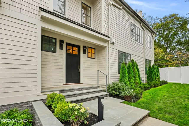 a front view of a house with potted plants