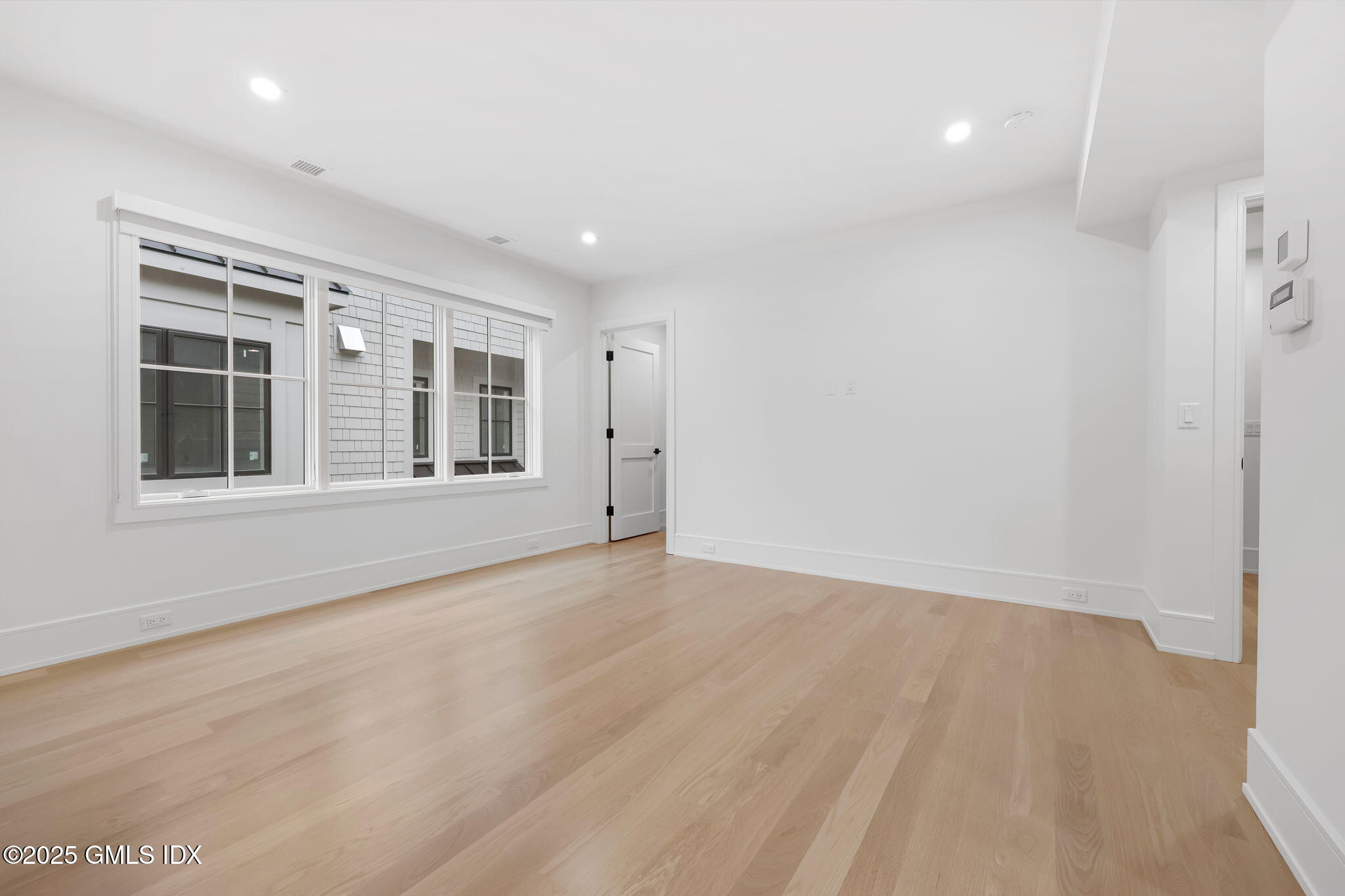 187 Field Point Road, Unit B Greenwich, CT 06830 - Photo 10 of 32 an empty room with wooden floor and windows