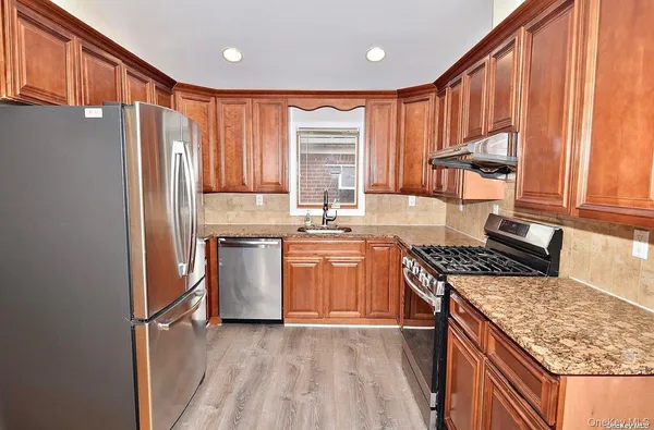 a kitchen with stainless steel appliances granite countertop a stove a sink dishwasher and a refrigerator