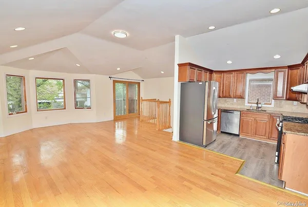 a view of kitchen with stainless steel appliances granite countertop a refrigerator and a sink