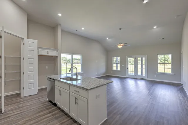 a large kitchen with granite countertop a sink and a refrigerator
