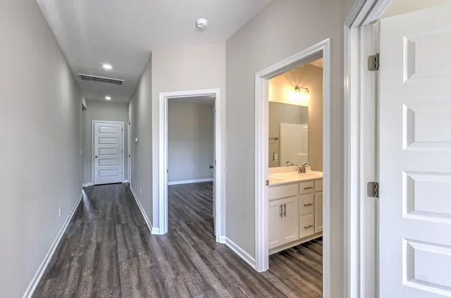 a view of a hallway with wooden floor and closet
