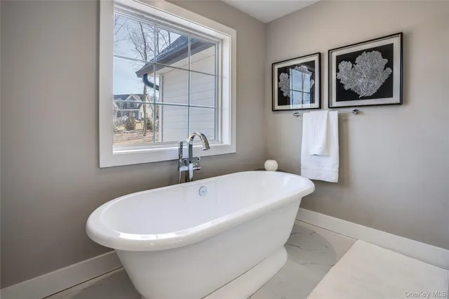 a white bath tub sitting next to a white walls