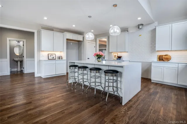 a kitchen with stainless steel appliances a dining table chairs and wooden floor
