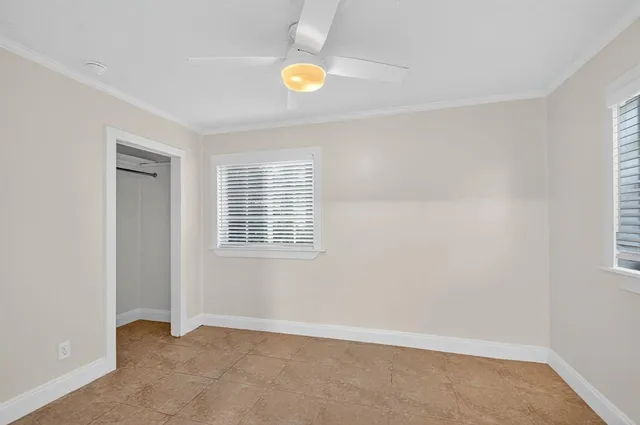 an empty room with window and closet