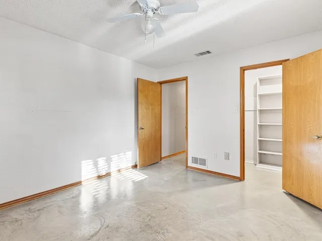 an empty room with a empty space and a ceiling fan