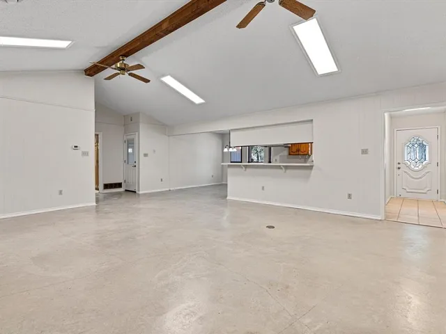 an empty room with staircase and a ceiling fan