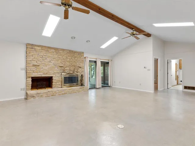 en empty room with windows and fireplace