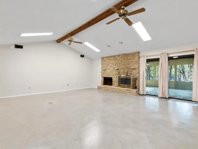 an empty room with windows and fireplace
