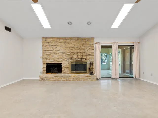 an empty room with a fireplace and sliding door