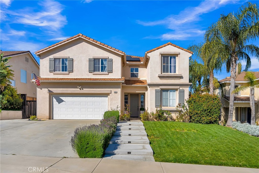 8361 Manhasset Street Riverside, CA 92508 - Photo 1 of 1 a front view of a house with a yard and garage