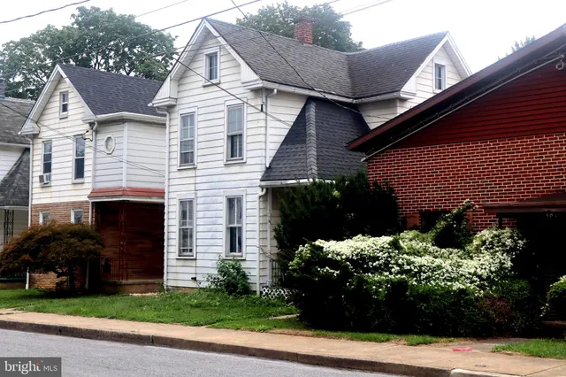 a front view of a house with a yard and a garden