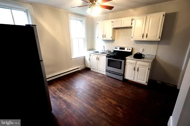 a kitchen with granite countertop a stove a sink and a microwave