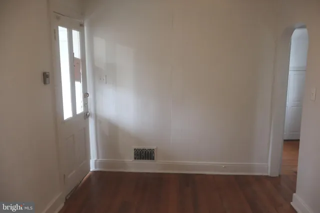 a view of a small space with wooden floor and a window