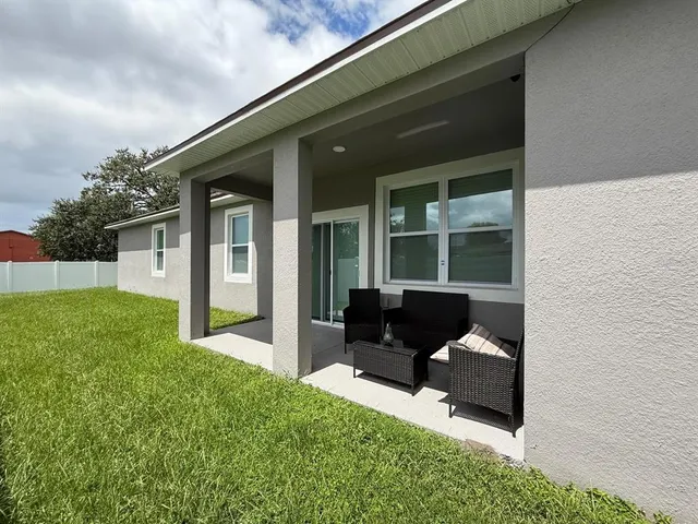 a view of a house with backyard sitting area and garden