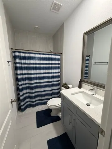 a bathroom with a sink a toilet a mirror and shower