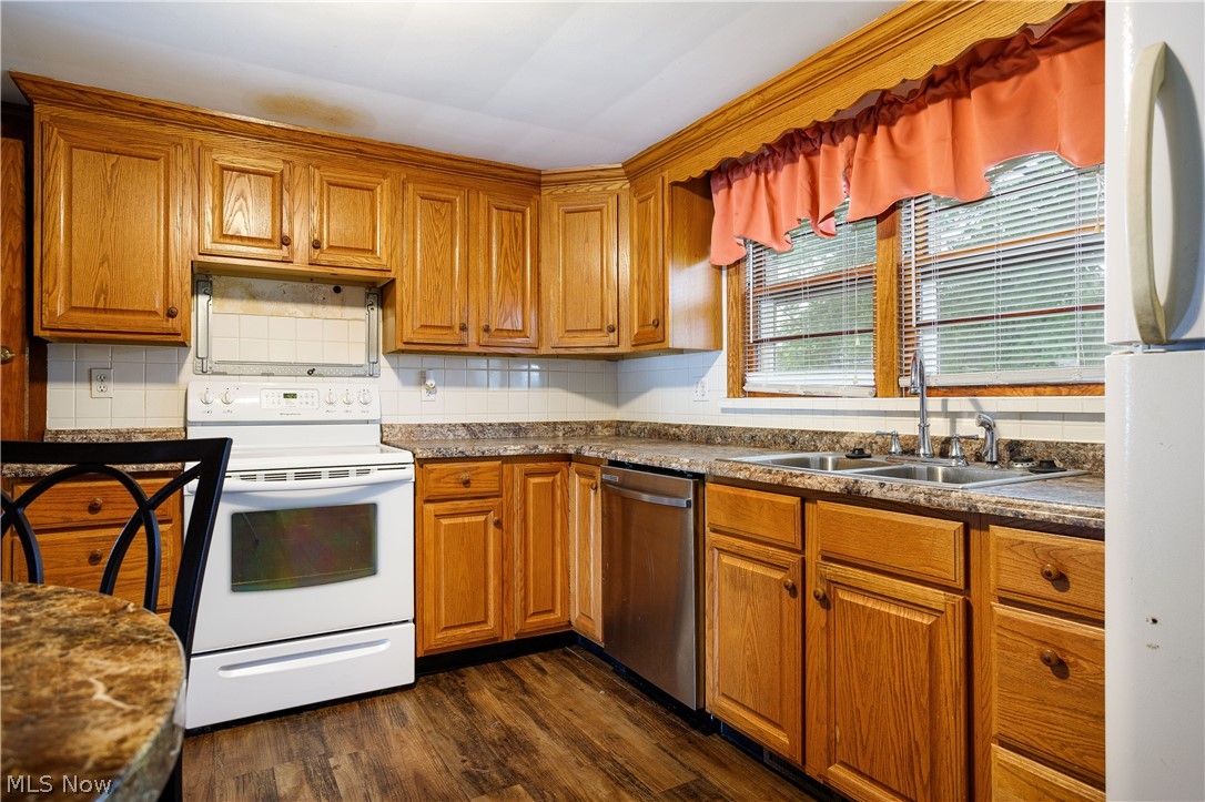 254 Johnson Road Wadsworth, OH 44281 - Photo 13 of 35 Kitchen featuring dark hardwood / wood-style floors, sink, tasteful backsplash, and white appliances