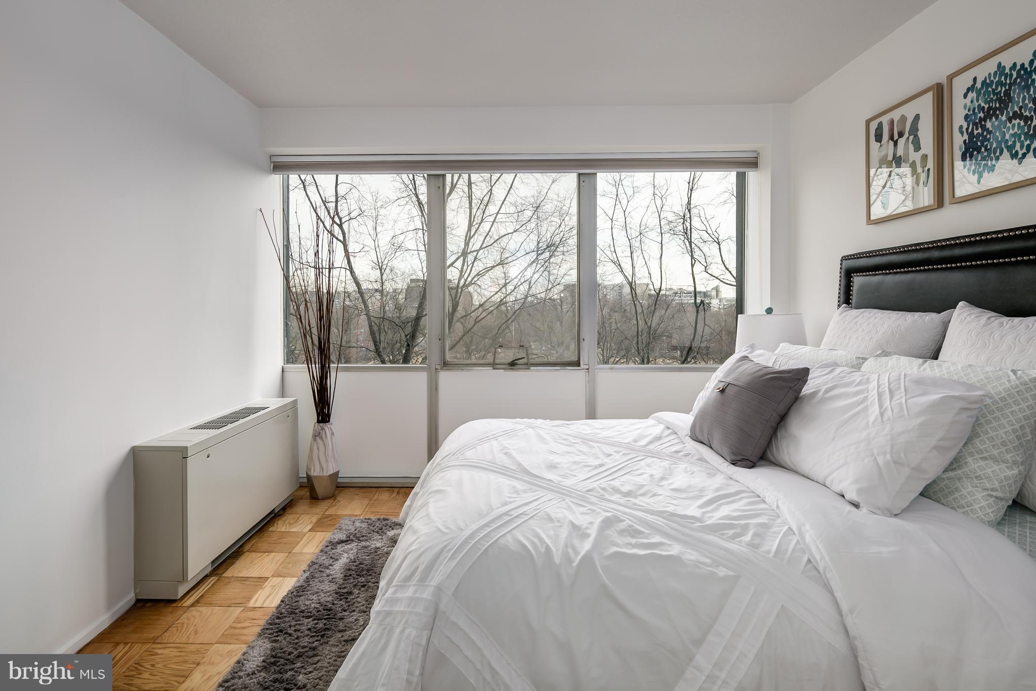 1301 Delaware Avenue Southwest, Unit N512 Washington, DC 20024 - Photo 11 of 28 a large white bed sitting in a bedroom next to a window