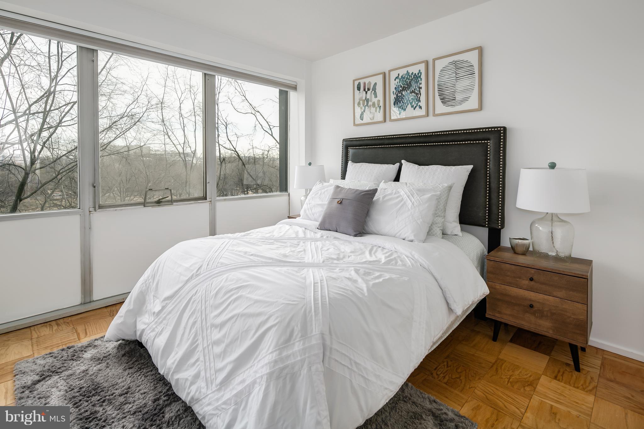 1301 Delaware Avenue Southwest, Unit N512 Washington, DC 20024 - Photo 12 of 28 a bedroom with a bed and glass window