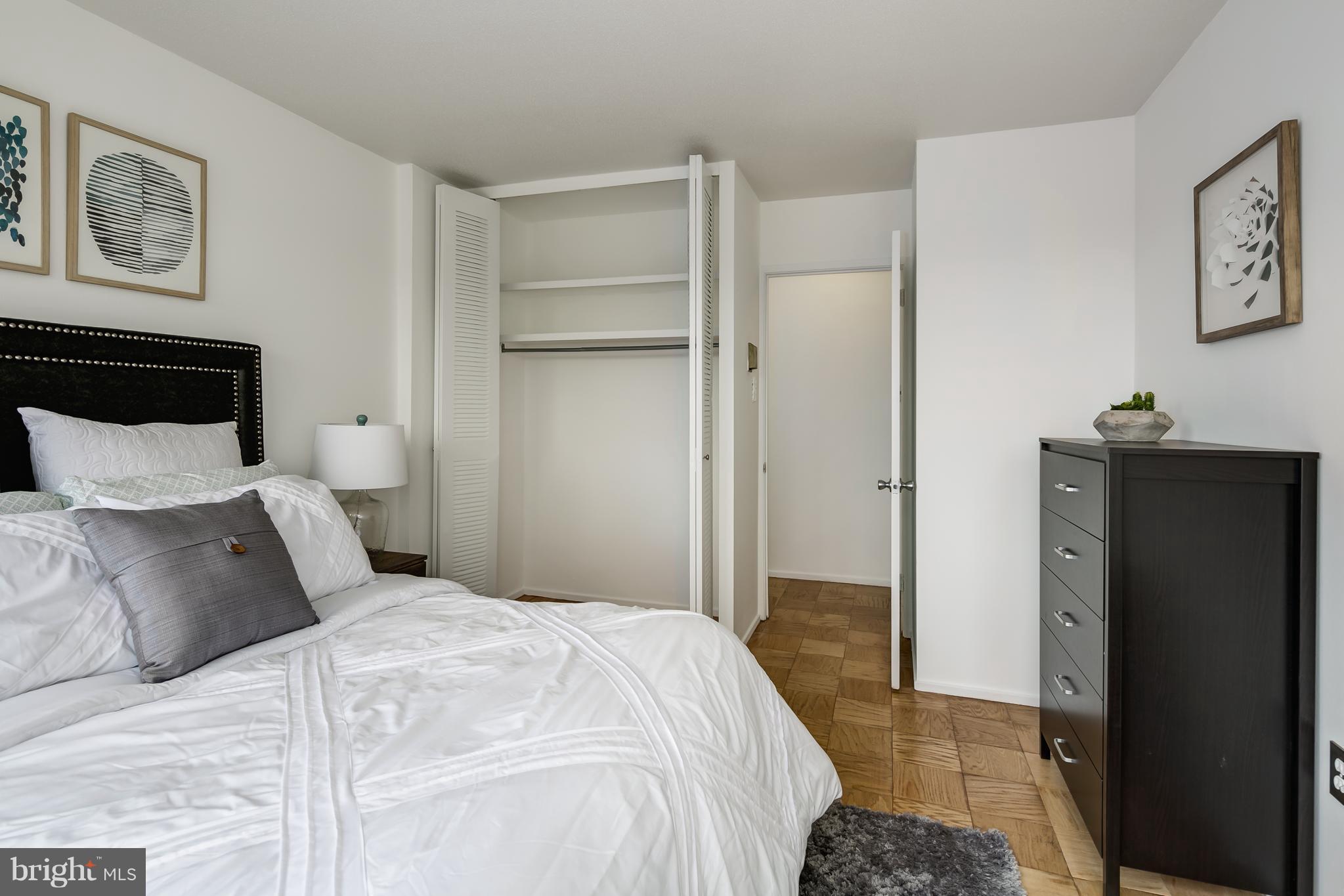 1301 Delaware Avenue Southwest, Unit N512 Washington, DC 20024 - Photo 13 of 28 a bedroom with a bed and a refrigerator