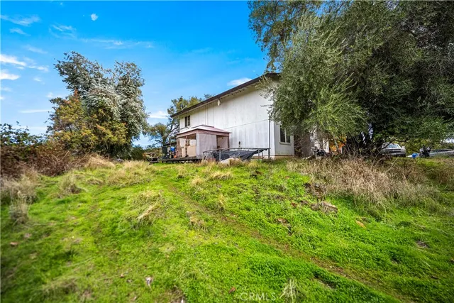 a view of a chair and table in backyard of the house
