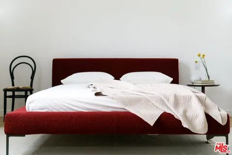 a bedroom with a bed and a lamp on the table