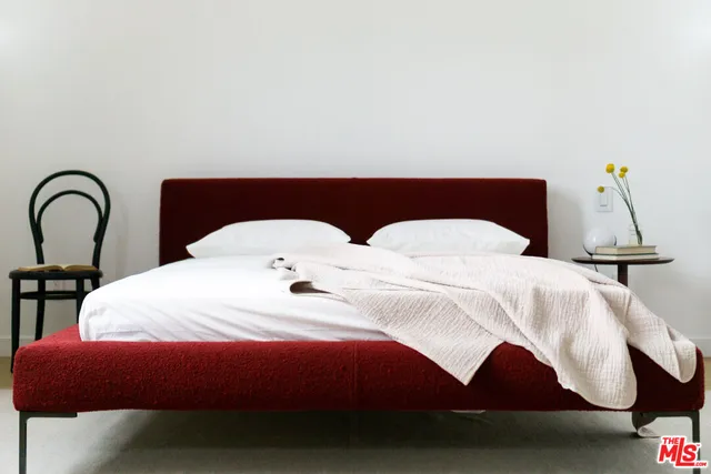 a bedroom with a bed and a lamp on the table