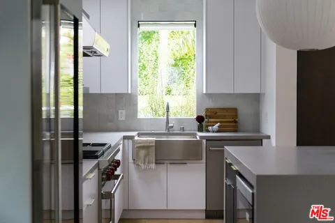a kitchen with a sink a window and appliances