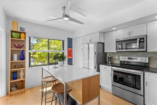 a kitchen with stainless steel appliances a stove a refrigerator and a kitchen island