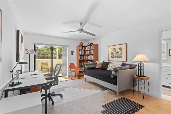 a living room with furniture a rug potted plant and a large window