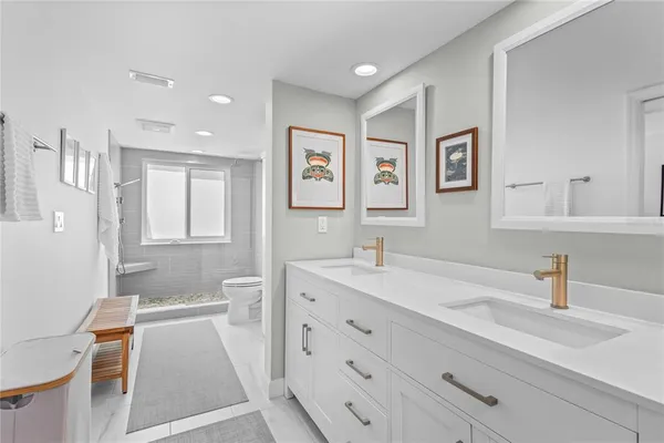 a bathroom with a sink double vanity granite tub and a mirror
