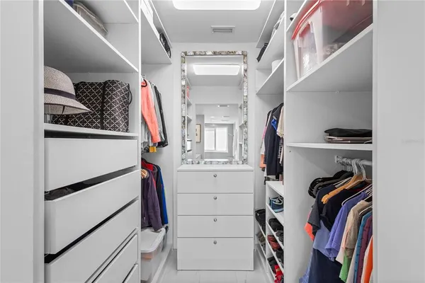a view of walk in closet with clothes and shoes