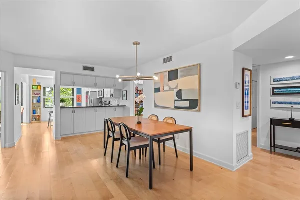 a living room with stainless steel appliances kitchen island granite countertop furniture and a wooden floor