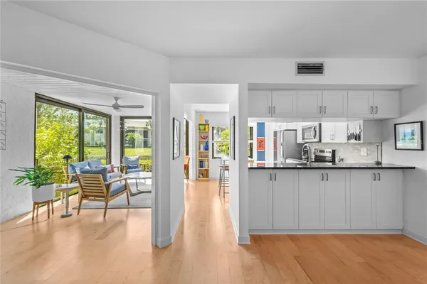 a open kitchen with granite countertop a stove top oven a sink with dining table and chairs
