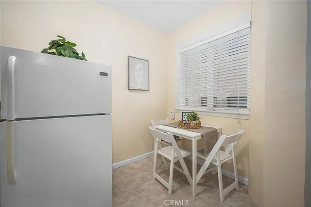 a dining room with furniture and a refrigerator