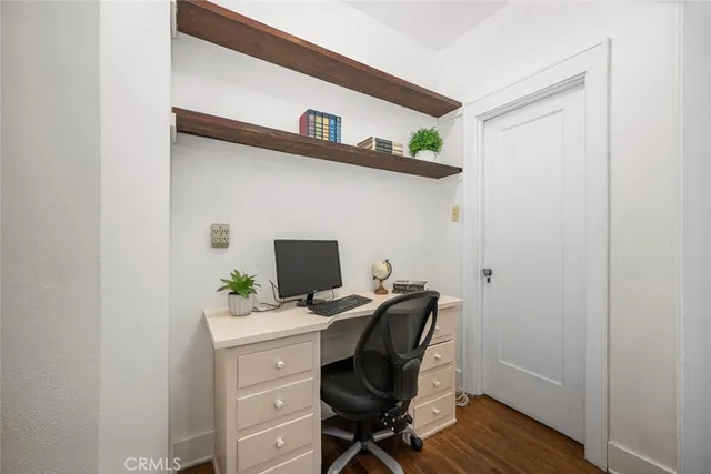 a view of a workspace with furniture and wooden floor